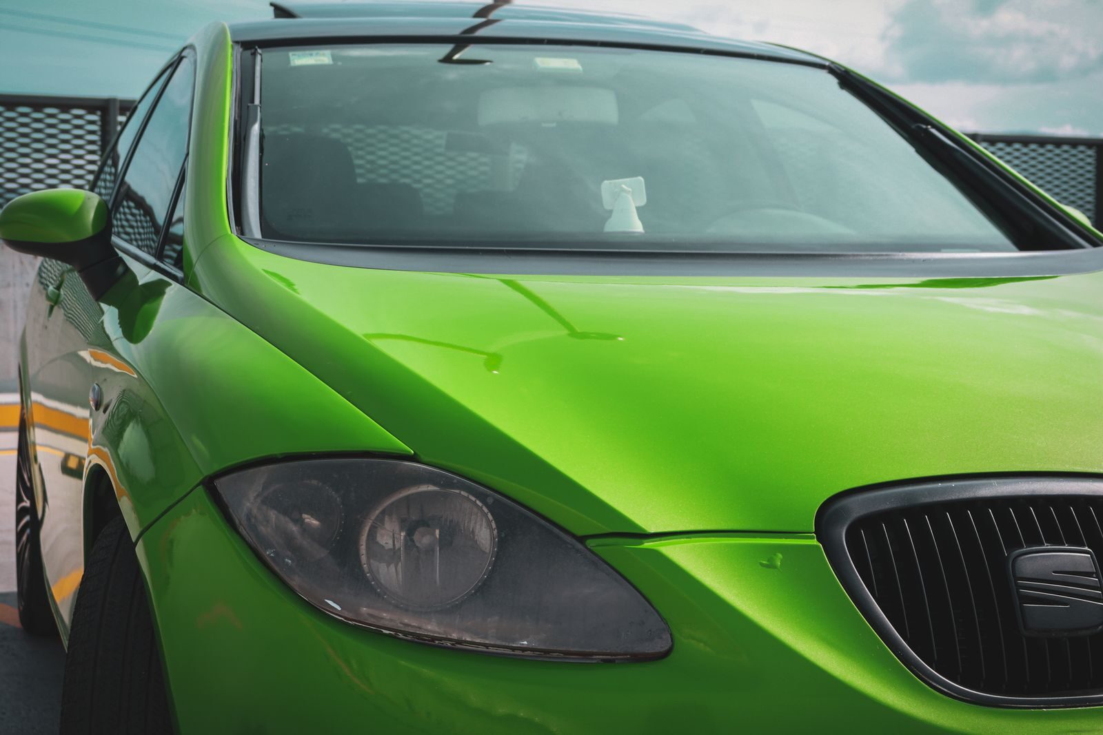 A close-up of a vibrant green car parked outdoors, capturing its sleek design.